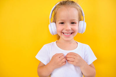 Portrait of cute girl against yellow background