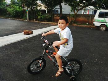 Boy riding bicycle on street