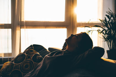 Woman relaxing on sofa at home