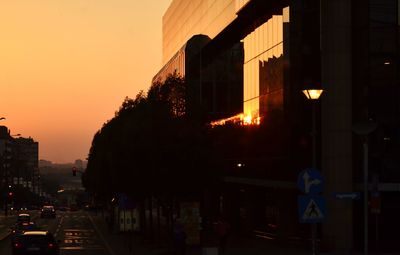 Illuminated city against sky at sunset