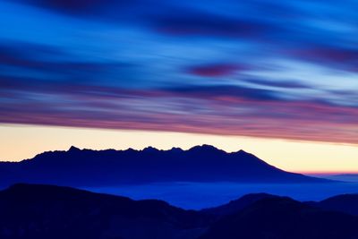 Scenic view of silhouette mountains against sky during sunset