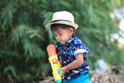 Boy wearing hat standing against blurred background