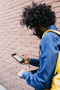 Man with backpack and e-scooter using navigation app on his mobile phone