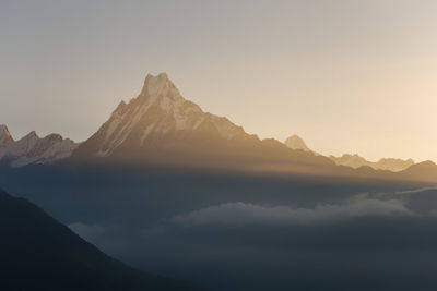 Scenic view of snowcapped mountains against sky during sunset