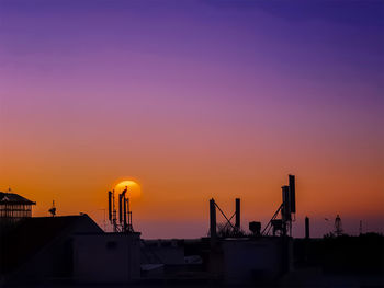 Silhouette of building against orange sky