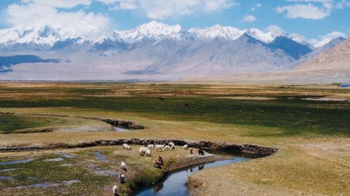 Scenic view of lake by mountains against sky