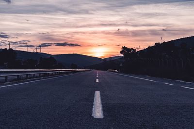 Surface level of road against sky during sunset