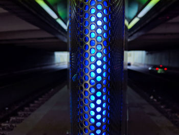 Close-up of illuminated lighting equipment on bridge at night