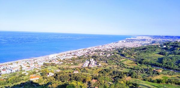 High angle view of townscape by sea against sky