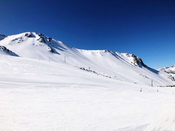 Scenic view of snowcapped mountains against clear blue sky