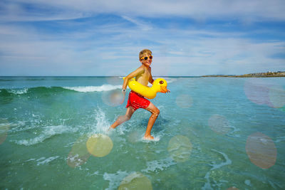 Full length of girl playing in sea