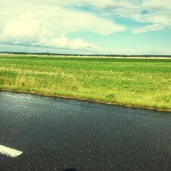 Scenic view of field against cloudy sky