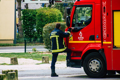 Rear view of a man standing on street in city