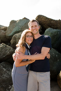 Mother & son hugging and smiling for camera at beach