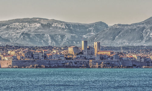 Scenic view of sea and cityscape against sky