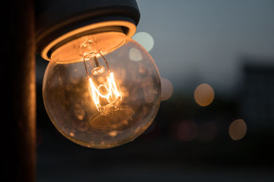 Close-up of light bulb hanging outdoors