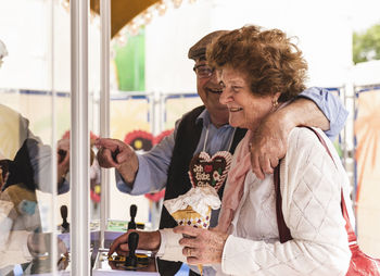 Senior couple having fun with gaming machine on fair