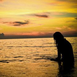 Silhouette of people in sea at sunset
