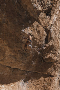 Climber hanging on rope on rough cliff