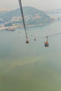 Overhead cable car over sea against sky