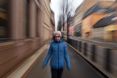 Portrait of girl standing on sidewalk in city