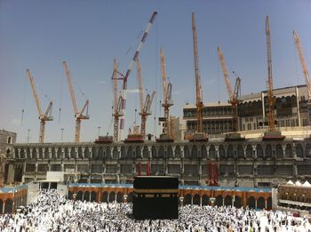 Cranes at construction site against sky in city