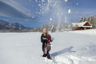 Woman is having winter fun on a snowy, sunny day in lika, croatia