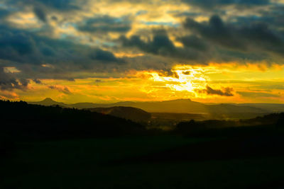 Scenic view of silhouette mountains against sky at sunset