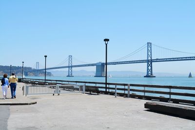 Man walking on bridge over sea