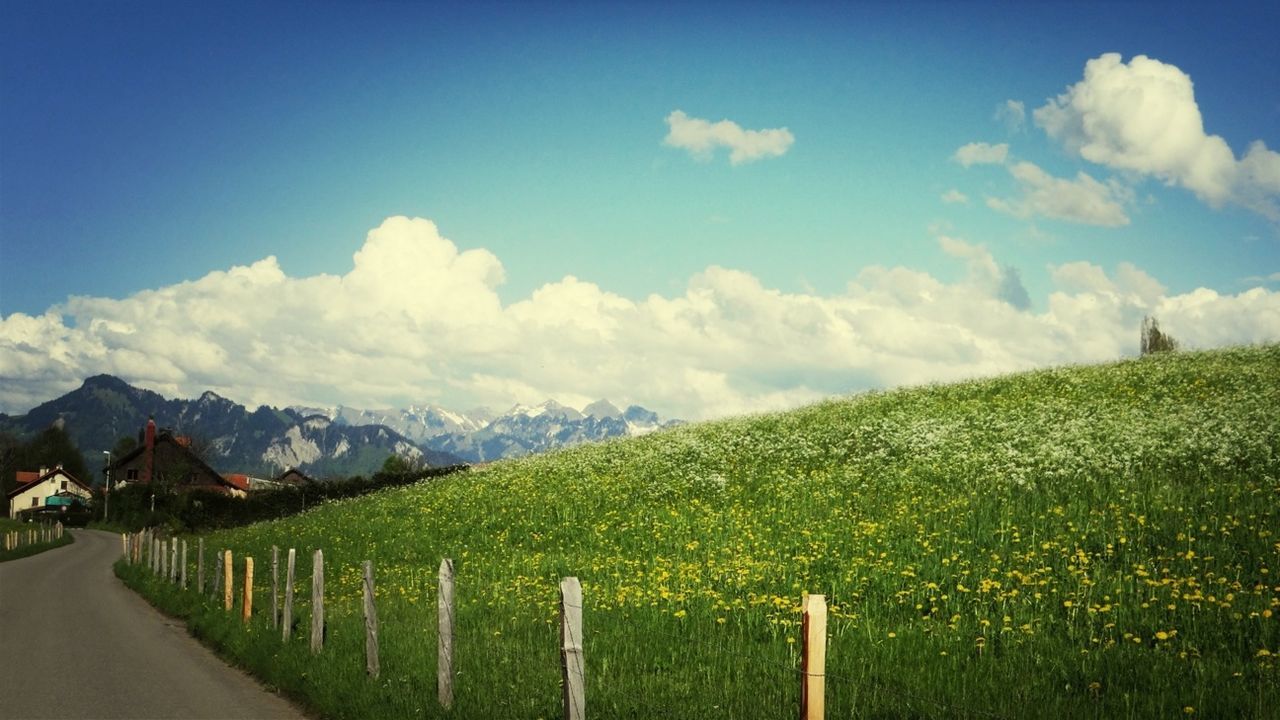 mountain, sky, landscape, tranquil scene, tranquility, field, grass, beauty in nature, scenics, nature, cloud - sky, mountain range, fence, cloud, rural scene, green color, agriculture, blue, growth, plant