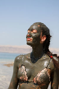 Beautiful woman with body covered with dead sea beneficial mud, jordan
