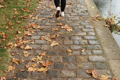 Low section of men walking on cobblestone