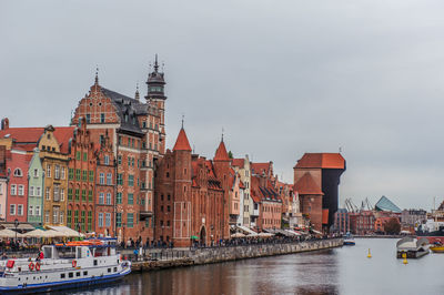 River amidst buildings in city against sky