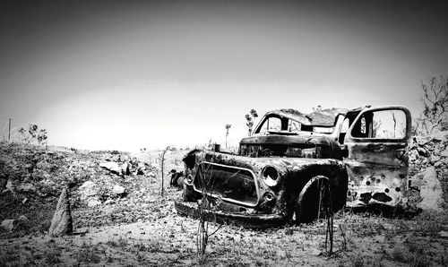 Old abandoned car on field
