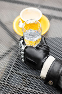 A hand with a bionic prosthesis holds a glass of water. a happy european cyber woman with a bionic