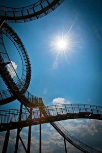 Low angle view of ferris wheel against cloudy sky