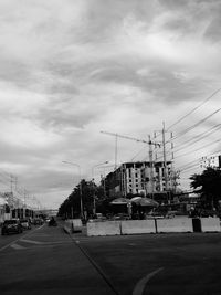 Cars on road against sky in city