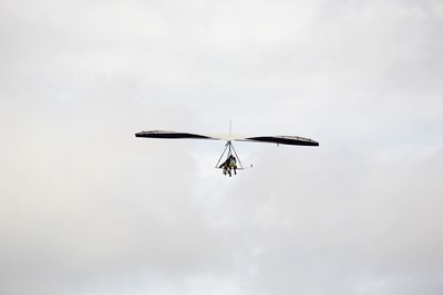 Low angle view of air vehicle flying in cloudy sky