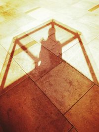 High angle view of shadow on tiled floor