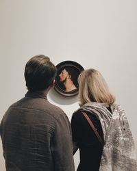 Rear view of couple standing against white background