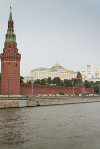 View of building by river against sky in city