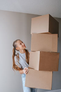 Side view of mother and daughter sitting on cardboard box