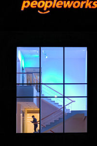 Illuminated text on glass window at night