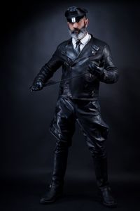 Full length of man wearing costume against black background