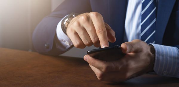 Midsection of man using mobile phone