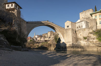 Arch bridge over river against sky