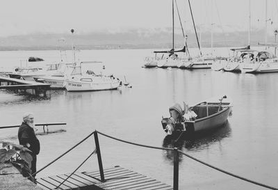 People on pier by sea against sky