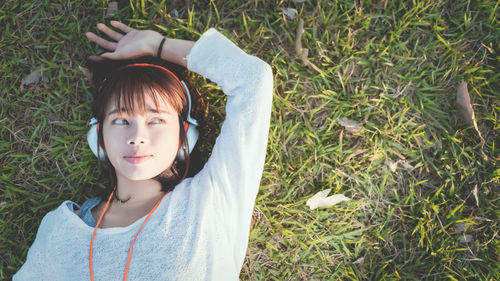 Portrait of young woman on grass in field