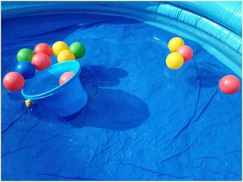 High angle view of balls and bucket in wading pool