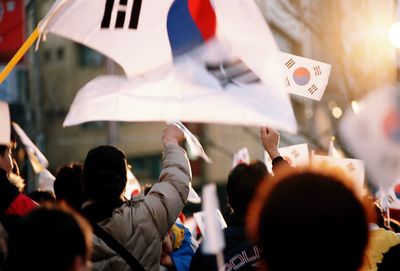 Group of people with flags protesting in city